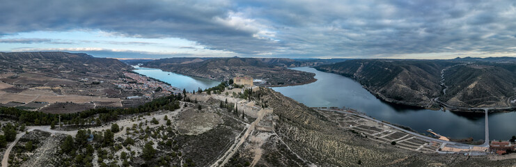 Aerial view of Mequinenza at the confluence of the Ebro between the Mequinenza Dam and Riba-roja reservoir. Fortification with angled bastions at strategic location, dramatic sky