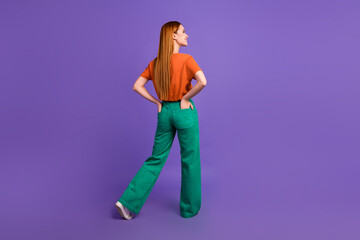 Fototapeta na wymiar Rear view photo of ginger model girl wearing trendy outfit put hands into pockets look novelty thoughts isolated on violet color background