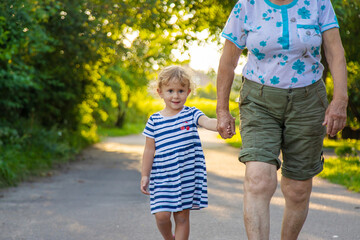 Child with grandmother holding hand. Selective focus.