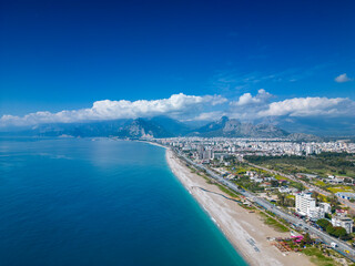 Stunning views of the beach, mountains and Konyaalti Park in Antalya, Turkey. A drone flies over the beach. Horizontal photo.