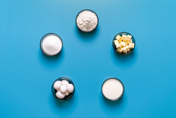 Sweets baking ingredients top view, isolated on a blue background