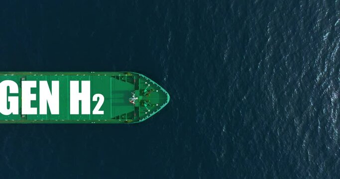 A large green ship in the blue ocean is carrying important cargo. The tanker uses hydrogen energy. Renewable energy for cargo transportation. Shipping is the engine of trade around the world