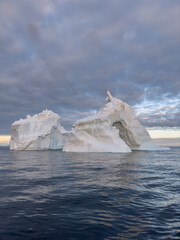 A huge high breakaway glacier drifts in the southern ocean off the coast of Antarctica at sunset,...