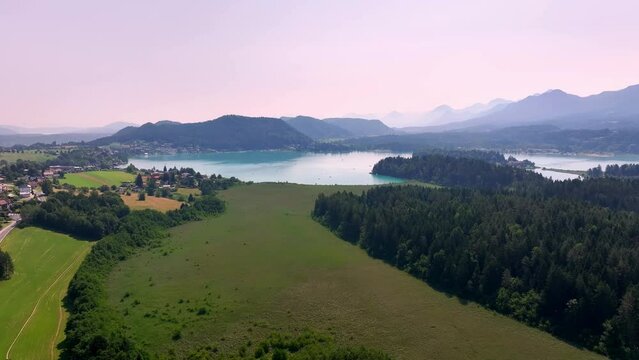aerial shot of faak's lake in the mountains in Austria on sunrise