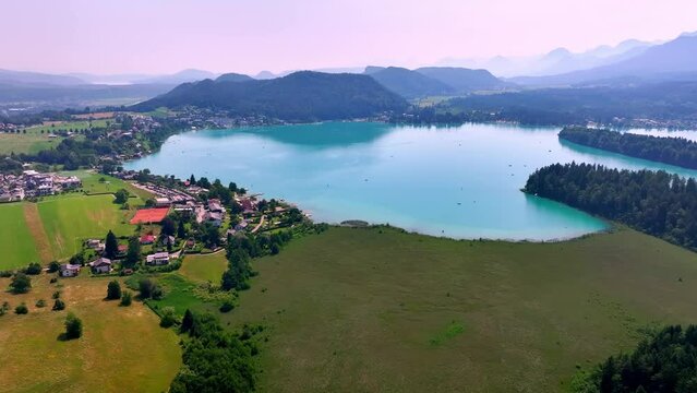 aerial shot of faak's lake in the mountains in Austria on sunrise