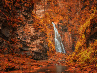 view to waterfall in canyon in autumn colours