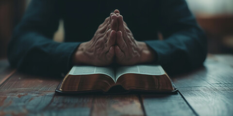 Man praying hands clasped together on Bible - obrazy, fototapety, plakaty