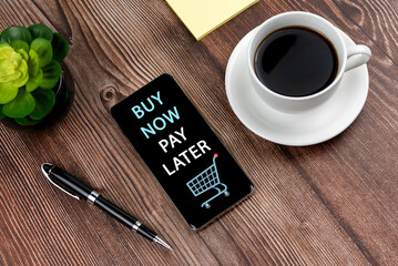 Buy now pay later shopping text on smart phone and cup of coffee - obrazy, fototapety, plakaty