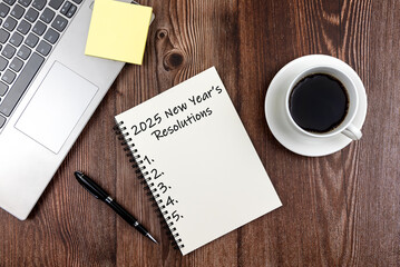 New Year's Resolutions 2025 text on note pad stock photo on wood desk
