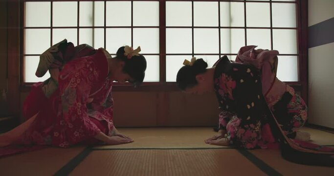 Japanese women, bow and traditional for culture on floor, tea ceremony and kindness in connection. People, worship together or spiritual in prayer in respect or relax wellness in peace or mindfulness