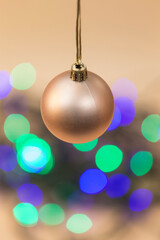 Fototapeta premium view of a hanging christmas ball and colored circles at the bottom of the image