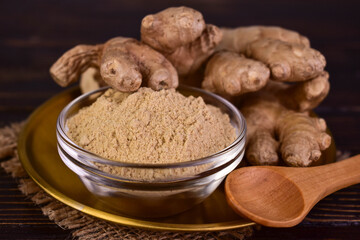 Ginger root and ginger powder in a glass bowl.Close-up.	