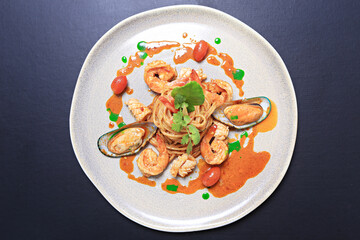 Spaghetti Tom Yum Seafood, Thai style fusion food, spicy pasta with squid, shrimp, new zealand mussels in tom yum sauce 
