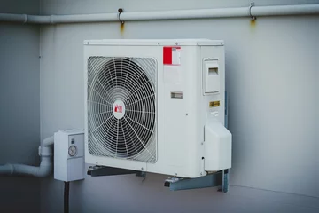 Foto op Plexiglas Air conditioning unit compressor on building wall outside, Installing air conditioner for adjusting comfortable temperature in hot summer © Lazy_Bear