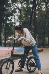 Obraz premium Happy Asian young woman walk and ride bicycle in park, street city her smiling using bike of transportation, ECO friendly, People lifestyle concept.