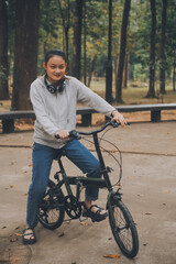 Obraz premium Happy Asian young woman walk and ride bicycle in park, street city her smiling using bike of transportation, ECO friendly, People lifestyle concept.