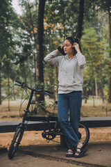 Fototapeta premium Happy Asian young woman walk and ride bicycle in park, street city her smiling using bike of transportation, ECO friendly, People lifestyle concept.