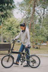 Happy Asian young woman walk and ride bicycle in park, street city her smiling using bike of transportation, ECO friendly, People lifestyle concept.