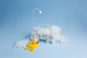children's holiday decoration of the photo zone. small baby bath with foam and rubber duckies. background texture the first photo session of a newborn