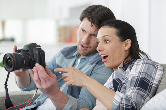 couple watching vacation pictures on a camera