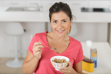 woman close up eating oat and fruits bowl for breakfast - Powered by Adobe