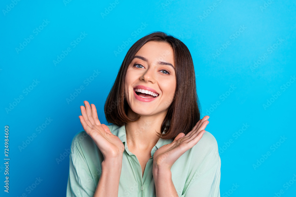 Canvas Prints Portrait of gorgeous lovely girl with stylish hair wear teal shirt palms demonstrate white toothy smile isolated on blue color background