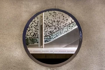 Foto auf Alu-Dibond Rotterdam, The Netherlands  View through a round opening in out of focus concrete wall of the Wilhelminaplein subway station with platform and escalator on other side © Sonja