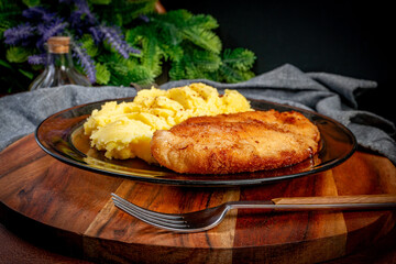 Breaded chicken breast fillet served with boiled potatoes and salad.