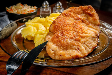 Breaded chicken breast fillet served with boiled potatoes and salad.