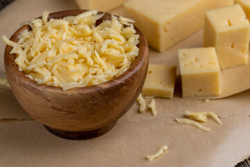 grated yellow semi-hard cheese with holes