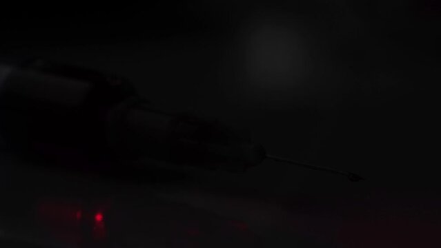 A syringe illuminated by police lights.