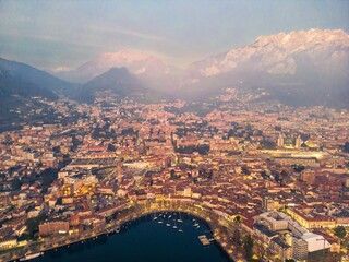 Drone shot of the city of Lecco and Lake Como at dusk, Italy. Mount Resegone in the background