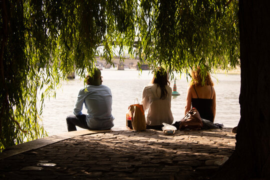Picnic on Seine River,  three young persons having a meal in downtown Paris
