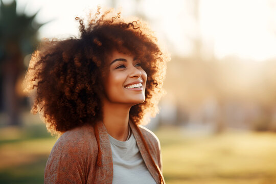 Beautiful African American Woman With Afro Hair Smiling And Looking Away Outdoors