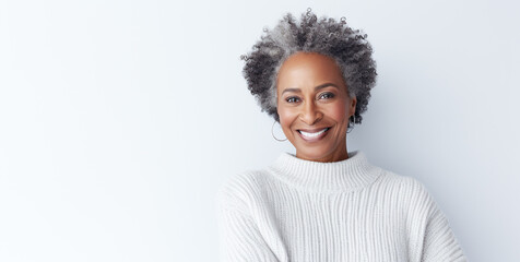 Smiling and elegant african american middle-aged woman wearing a cozy sweater conveying happiness. Copy Space.
