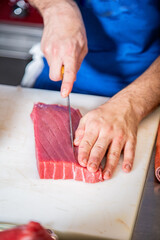 Chef corta atún rojo fresco salvaje en lomos para hacer tataki y sushi de atún rojo delicioso...