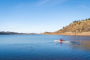 Senior male rower is rowing a coastal rowing shell - Carter in fall or winter scenery in northern Colorado.