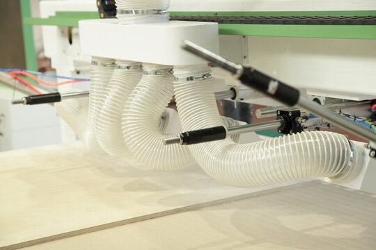 Big plastic pipes of dust removal system of the woodworking machine