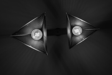 Black and white hanging dangling ceiling lamp in front of a dark background