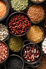 Legumes, a set consisting of different types of beans, lentils and peas on a black background, top view, close up. The concept of healthy and nutritious food