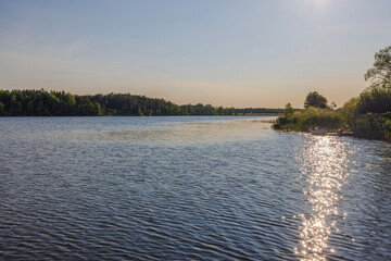 Beautiful view of sunset casting warm hues over tranquil lake on summer day. Sweden.