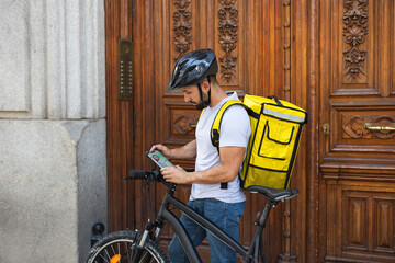 delivery man looking at the map on his smartphone to check the delivery and shipping address