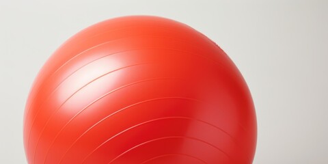 A red exercise ball sitting on top of a table. Perfect for fitness and exercise concepts