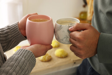 Couple drinking coffee at home, closeup view