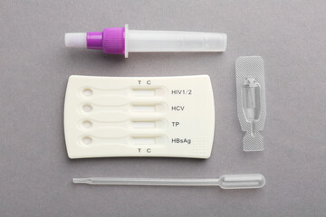 Disposable multi-infection express test kit on grey background, flat lay