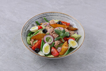 salad with tuna, quail eggs and baked potatoes on a stone background, studio food photography 4