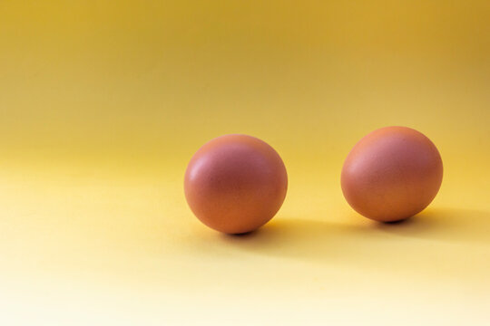 two chicken eggs isolate on a yellow background