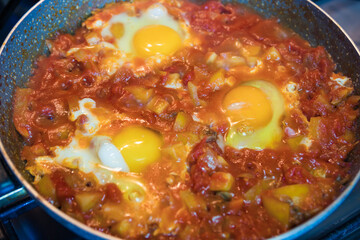 Shakshuka traditional Israeli food. Shakshuka is a Jewish-origin dish of eggs in a sauce of tomatoes, chili peppers, and onions, often spiced with cumin.