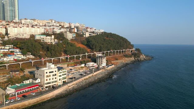Drone footage of Haeundae blueline architectures with blue sea and blue sky in Busan, Korea