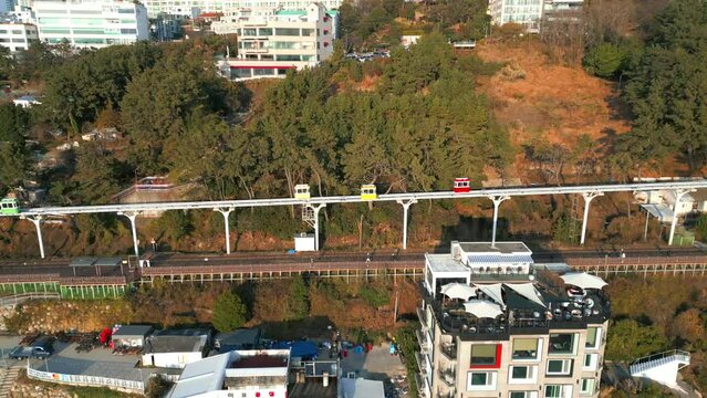 Drone footage of Haeundae blueline architectures with the Colorful sky capsule trains in Busan